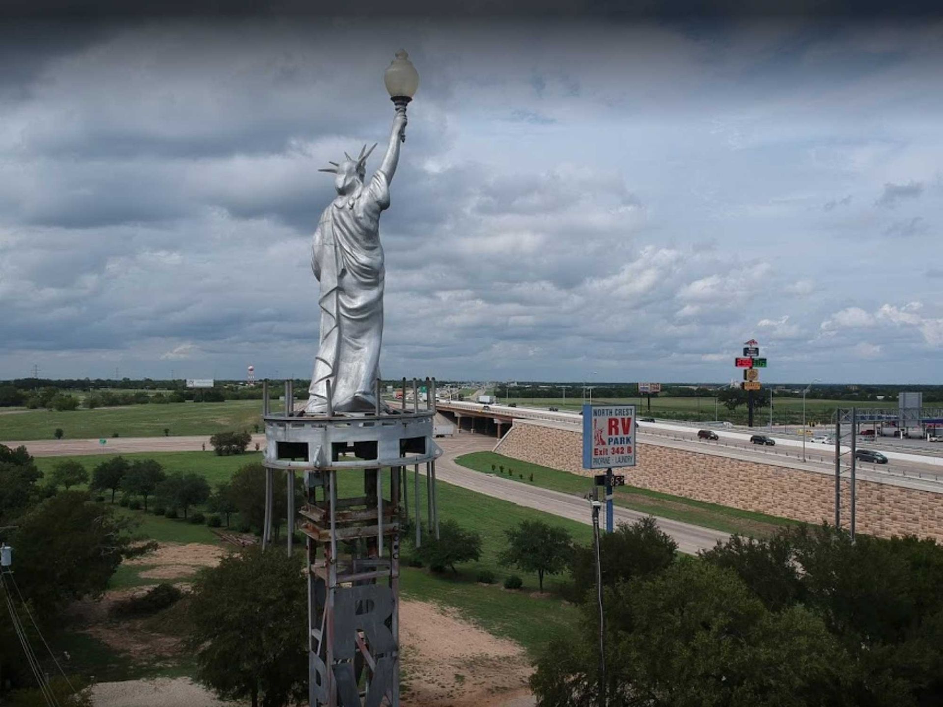 The towering Statue of Liberty landmark beside I-35 at North Crest RV Park